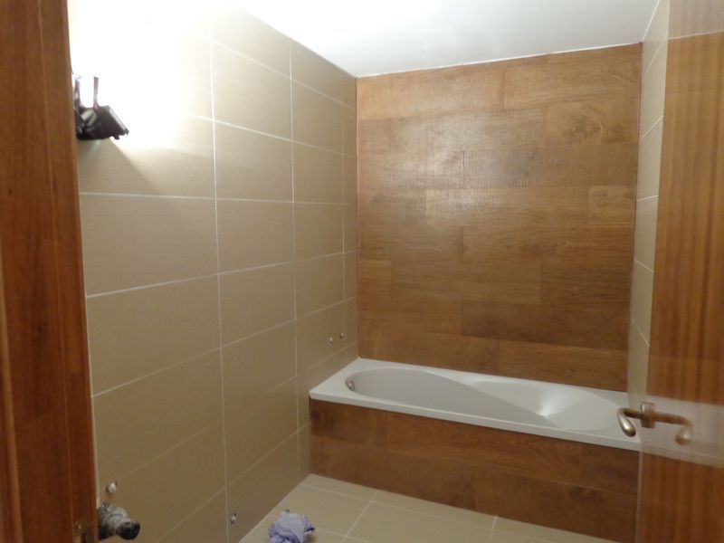 Pared del fondo revestida con azulejo imitación madera